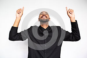 Portrait of happy young businessman pointing upwards