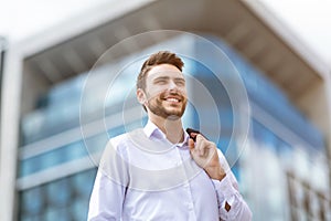 Portrait of happy young businessman on street of big city