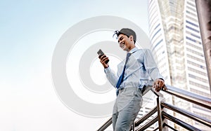 Portrait of a Happy Young Businessman Using Mobile Phone in the Urban City