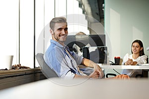 Portrait of a happy young casual businessman at office, smiling.