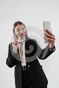 Portrait of happy young caucasian business woman using smartphone on isolated white gray background