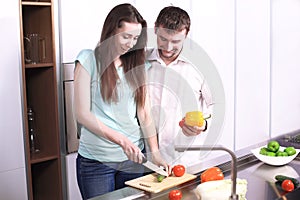 Portrait of happy young couple cooking together in the kitchen.