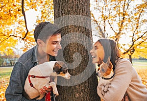 Portrait of happy young couple with dogs outdoors in park