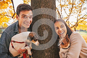 Portrait of happy young couple with dogs outdoors in park