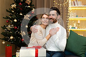 Portrait of a happy young couple, family. Young man and woman celebrating Christmas holidays at home