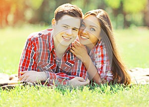Portrait happy young couple having fun smiling lying on grass