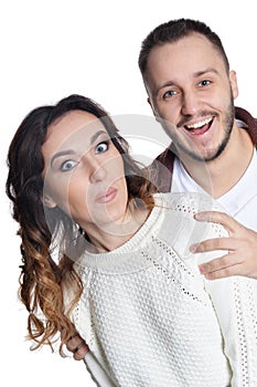 Portrait of happy young couple hugging on white background