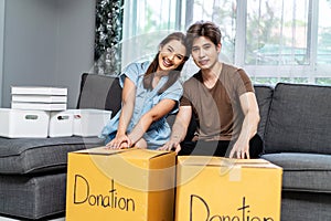 Portrait of a happy young couple packing stuff clothes, object charity in cardboard box, reused for donate, Product recycle or
