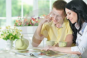 Portrait of happy young couple reading interesting book