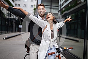 Portrait of happy young couple riding a bike and having fun together outdoor