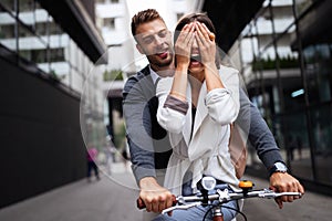 Portrait of happy young couple riding a bike and having fun together outdoor