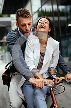 Portrait of happy young couple riding a bike and having fun together outdoor