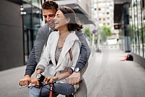 Portrait of happy young couple riding a bike and having fun together outdoor