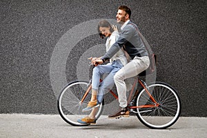 Portrait of happy young couple riding a bike and having fun together outdoor