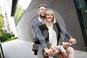 Portrait of happy young couple riding a bike and having fun together outdoor