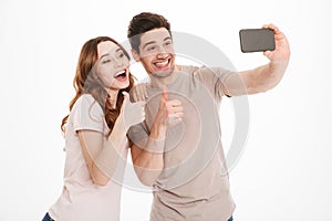 Portrait of a happy young couple showing thumbs up