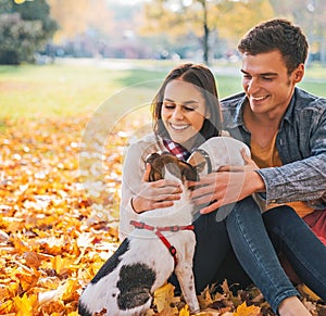 Portrait of happy couple sitting outdoors in autumn park