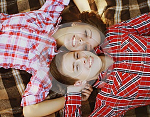 Portrait of happy young couple teenagers lying together on plaid