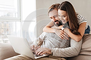 Portrait of a happy young couple using laptop computer