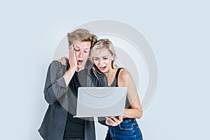 Portrait of happy young couple using laptop computer in studio