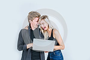 Portrait of happy young couple using laptop computer in studio