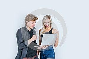 Portrait of happy young couple using laptop computer in studio