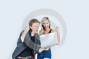 Portrait of happy young couple using laptop computer in studio