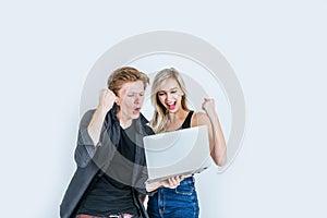 Portrait of happy young couple using laptop computer in studio