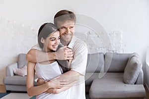 Portrait of happy young family dreaming about future together