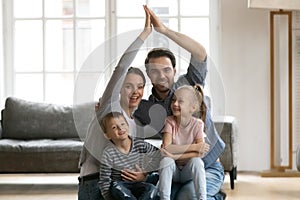 Portrait of happy young family with kids in new home