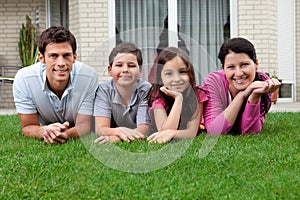 Portrait of happy young family lying on grass