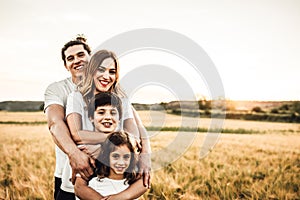 Portrait of a happy young family smiling in the countryside. Concept of family fun in nature