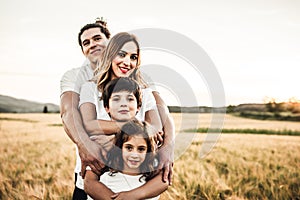 Portrait of a happy young family smiling in the countryside. Concept of family fun in nature