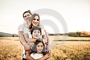 Portrait of a happy young family smiling in the countryside. Concept of family fun in nature