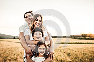 Portrait of a happy young family smiling in the countryside. Concept of family fun in nature