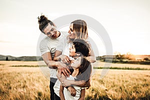 Portrait of a happy young family smiling in the countryside. Concept of family fun in nature