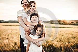 Portrait of a happy young family smiling in the countryside. Concept of family fun in nature