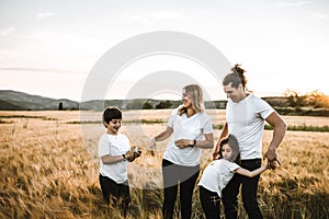 Portrait of a happy young family smiling in the countryside. Concept of family fun in nature