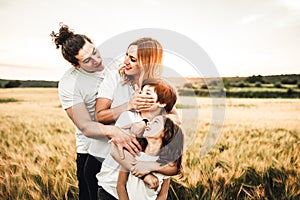 Portrait of a happy young family smiling in the countryside. Concept of family fun in nature