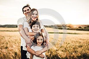 Portrait of a happy young family smiling in the countryside. Concept of family fun in nature