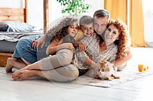 Portrait of a happy young family with two children and red fluffy cat