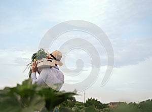 Portrait of a happy young farmer holding fresh vegetables in a basket. On a background of nature The concept of biological, bio