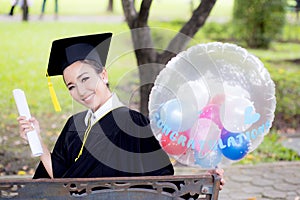 Portrait of happy young female graduates in academic dress and square academic cap