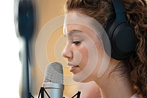 Portrait of happy young female radio host broadcasting in studio