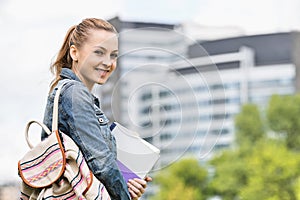 Portrait of happy young female student at college campus