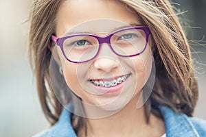 Portrait of happy young girl with dental braces and glasses