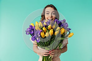 Portrait of a happy young girl in dress holding big bouquet