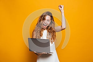 Portrait of a happy young girl holding laptop computer