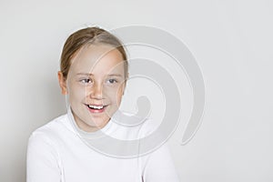Portrait of happy young girl laughing on white studio wall background