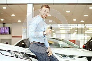 Portrait of happy young guy after successful purchase of new car
